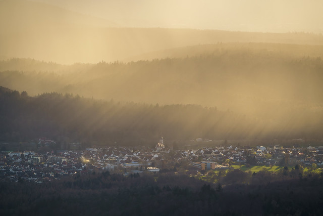 The low sun casts long shadows over Bad Rotenfels in the Black Forest during an approaching rain shower