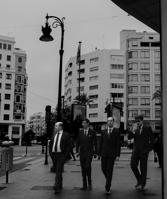 Some guys in suits walking on the corner