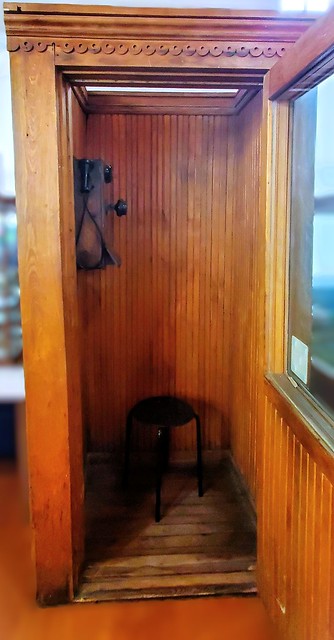 Very old wooden phone booth, with very old phone