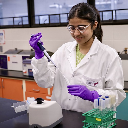 Arshpreet Khattra in lab coat working in lab.
