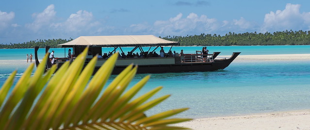 A traditional wooden Cook Islands vessel in the astoundingly blue waters of the Aitutaki lagoon in the South Pacific.