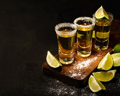 Mexican Gold Tequila with lime and salt on wooden table
