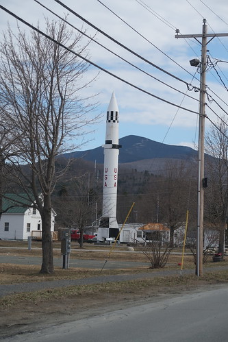 PGM-11 Redstone Nuclear Missile Warren, New Hampshire

WHY IS THERE A MISSILE HERE?
You are looking at an authentic Redstone Missile used by the US Army from 1958-1964 as a nuclear weapon, and by NASA from 1953-1961 as a space launch vehicle. In 1971, Warren native Sgt. First Class Henry &amp;quot;Ted&amp;quot; Asselin was ending his 22-year service in the US army, including two tours in Vietnam where he was awarded a Silver Star, a Bronze Star, and a Purple Heart. His final post was at the Redstone Arsenal in Huntsville, Alabama. 

Though the Redstone had been replaced by the Perishing missile, the arsenal still had three Redstones on base. When Ted learned that these last Redstones were going to be destroyed, he got the idea of taking one home with him upon his discharge. &amp;quot;I thought of the children,&#039; Ted recounted, &amp;quot;who were far removed from America&#039;s space program, except for television, and that seeing the real thing might interest some child in science and the space program. After all, Alan Shephard Jr. was a New Hampshire boy, and he made his historic suborbital flight back in 1961 aboard a Redstone.&amp;quot; 

The army brass agreed to give Ted a Redstone as long as he incurred the cost of its relocation. Though the town contributed $300 to the cause, Ted and his wife Sheila paid $2,000 out of their own pocket. In a borrowed truck and rented flatbed trailer, Ted arrived with the missile just before midnight on April 21,1971. It took 3 days to make the 1,300 mile journey from Huntsville, Alabama to Warren.


THE REDSTONE MISSILE SPECIFICATIONS
While one can get quite technical defining the difference between a missile and a rocket, a common distinction, and one that we use here, is that a missile carries an explosive and a rocket carries a capsule, satellite, or other space cargo. The missile before you is designated a PGM-11 Redstone by the U.S. Army, while the Redstone that propelled Alan Shepard on America&#039;s first human space flight was designated a Mercury Redstone by NASA. Though of the same family, they had different operating specs. The specs below are for the missile before you, the PGM -11.

Length: 69 ft. 4 in.
Height from foundation pad: 71 ft. 10 in.
Diameter: 70 in.
Thrust: 78,000 lbs.
Weight dry: 16,512 lbs.
Weight fueled: 61,346
Max payload: 6,305 lbs.
Max burn time: 119 sec.
Max speed during burn: Mach 4.8 (8,000 mph)
Max altitude: 57 miles
Maximum range: 175 miles
Warhead: W-39 thermonuclear (253 times more powerful than the bomb dropped on Hiroshima)


THE REDSTONE AND SPACE
Wernher von Braun&#039;s childhood dream was to develop rockets for space, not war. He envisioned humans one day traveling to the moon, and then Mars. The first step of this dream was accomplished on January 31, 1958 when a modified Redstone launched the first American satellite into orbit. This success led the Redstone to be chosen for launching the first primate and the first U.S. citizen into space. A chimpanzee named Ham splashed down after traveling aboard a Redstone on January 1, 1961. 

New Hampshire native Alan Shepard made his space flight via a Redstone on May 5, 1961. Wernher von Braun, now the head of NASA&#039;s Marshall Space Flight Center, was in charge of the launch. Shepard was secured atop the Redstone at 6:10 in the morning for a scheduled 7:00 am blast off. However, a series of malfunctions delayed the launch. After hours strapped to his seat, Shepard asked to use the bathroom. Von Braun gave an emphatic &amp;quot;No&amp;quot;. The time this would take could scrub the mission. Shepard then asked if he could relieve himself in his space suit. Because he had electrodes attached to his chest and neck to measure his heart rate and respiration, the NASA team worried that the electrodes could short out and injure their astronaut. Finally, after much back and forth, von Braun gave the go ahead and Shepard let go. After being informed of another delay, Shepard replied, &amp;quot;Why don&#039;t you fix your little problem and light this candle!&amp;quot; Lift off finally occurred at 9:34 am launching Shepard, and the Redstone before you, into history.