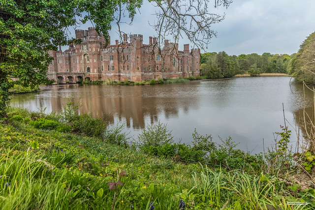 Herstmonceux Castle and its lake-like moat seen from the south-east, East Sussex, England.