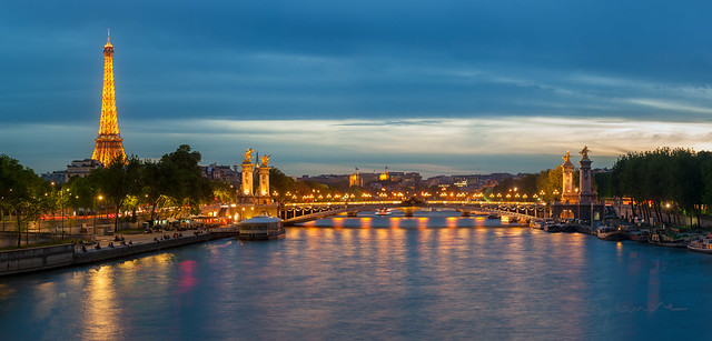Alexandre III bridge and Eiffel tower illuminated at dusk in Paris