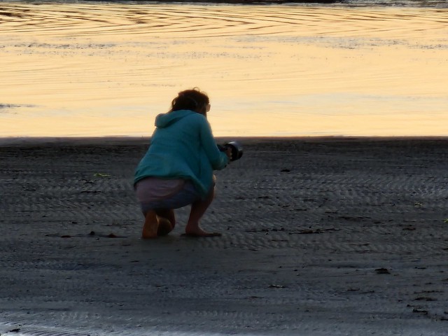 Woman taking sunset photos at Quiet Corner, Ricketts Point, Beaumaris on a chilly Autumn Sunday