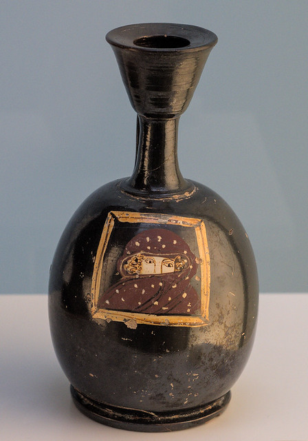 Apulian Black Gloss lekythos with superposed representation of a manteled woman in a window