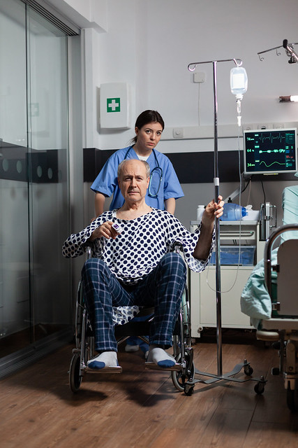 Medical practitioner preparing senior sick hospitalized man