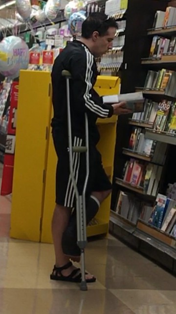 Reading in the supermarket with a broken foot and crutches - July 2023
