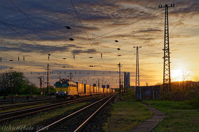GySEV 430 324 durchfährt kurz vor Sonnenuntergang mit einem KLV-Zug den Bahnhof Budapest-Ferencvaros.