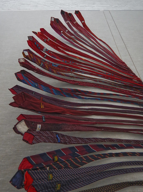 detail of the dark red ties from an graduated colour array of men's ties flying out from the wall