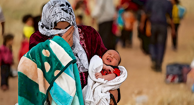 A young mother fleeing Syria with her baby (Flickr - UNHCR Photo Unit)