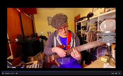 screen shot of Steve Lawson teaching bass on Zoom. He is holding a 6 string bass and looking down at the neck