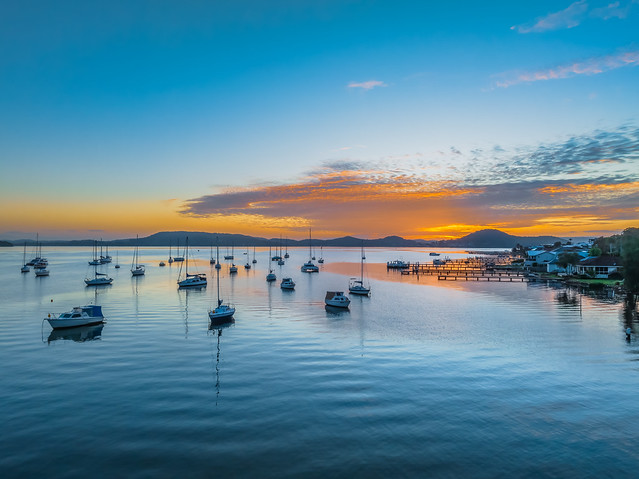 Sunrise over the water with boats and reflections