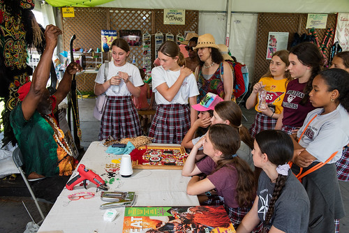 Schoolgirls learn about beading from Big Chief Victor Harris at Jazz Fest on April 26, 2024. Photo by Ryan Hodgson-Rigsbee.