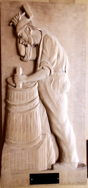 Bas relief wooden sculpture of a cooper