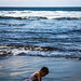 A little boy playing by the shore off the Balinese coast.
