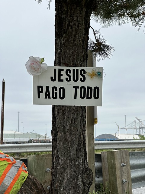 Signs and memorials along the road near the Key Bridge