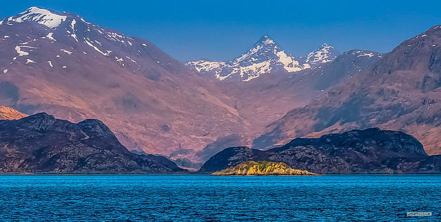Remote and wildly beautiful. Knoydart near the entrance to Loch Nevis, fjord country, from the Mallaig to Armadale Ferry. The iconic pyramidal landmark, Sgurr na Ciche dominates even being nigh on 20 miles distant, Inverness-shire, Scotland.