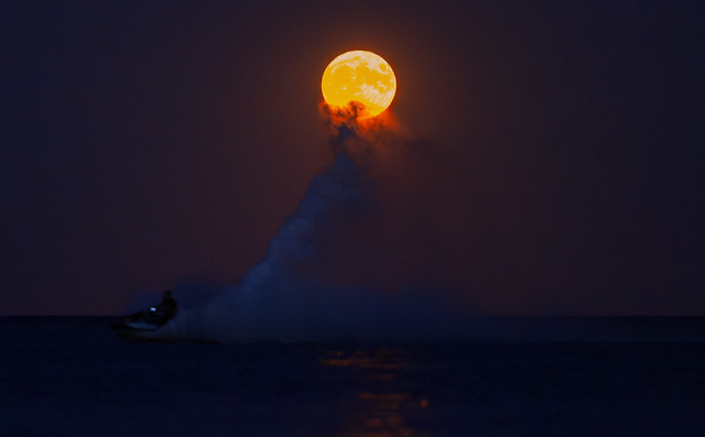 Full moon held up by a wave