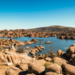 Looking east across Watson Lake - Prescott The view from the west shore looking east across the north part of Watson Lake just below the Dam. This really shows the Granite Dells. 

&lt;a href=&quot;https://en.wikipedia.org/wiki/Watson_Lake_&quot; rel=&quot;noreferrer nofollow&quot;&gt;en.wikipedia.org/wiki/Watson_Lake_&lt;/a&gt;(Arizona)
&amp;quot;Watson Lake is one of two reservoirs at the Granite Dells, in Prescott, Arizona, that was formed in the early 1900s when the Chino Valley Irrigation District built a dam on Granite Creek. The City of Prescott bought the reservoir and surrounding land in 1997 to preserve it as recreational land. Local rockclimbers use the granite cliffs above and adjacent to the lake for top-roping and lead climbing. The lake is also the home of TriCity Prep Rowing Crew, a local high school team and only rowing team in Northern Arizona.

&lt;a href=&quot;https://prescott-az.gov/rec-services/recreation-areas-prescott/lakes/watson-lake/&quot; rel=&quot;noreferrer nofollow&quot;&gt;prescott-az.gov/rec-services/recreation-areas-prescott/la...&lt;/a&gt;
&amp;quot;Located about four miles from downtown Prescott, Watson Lake offers a variety of outdoor activities for everyone. Boating enthusiasts will find convenience with two boat launches and options for canoe and kayak rentals. Fishing is a delight with carp, catfish, crappie, and largemouth bass swimming in the lake. If bird watching is your passion, head to the nearby Watson Woods Riparian Preserve, endorsed by the Audubon society, boasting hundreds of bird species including eagles and pelicans.
&amp;quot;For hikers, the easily accessible Peavine and Iron King Trails, both close to the lake, provide a pleasant and relatively flat terrain. During the summer months, visitors can set up camp at the available campsites, equipped with restrooms, showers, picnic tables, grills, fish cleaning stations, and a boat ramp. &amp;quot;

untitled-355.jpg