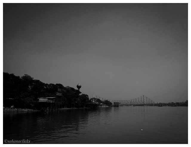 Hooghly river with magnificent Howrah Bridge at far end.. Kolkata, India