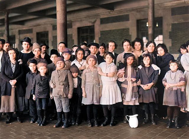 Children and adults pose inside one of Ellis Island's buildings