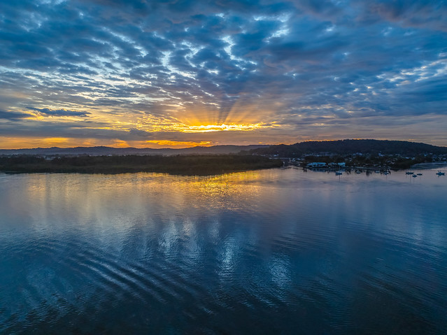 Sunrise over the bay water with clouds and reflections