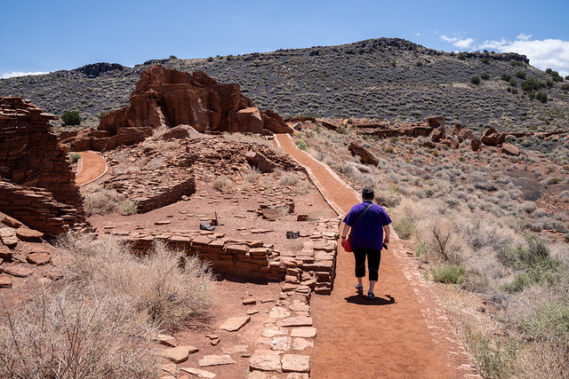 Arizona, USA - May 11, 2021: Senior mature woman tourist walks the path at Wupatki National Monument to explore the puebloes