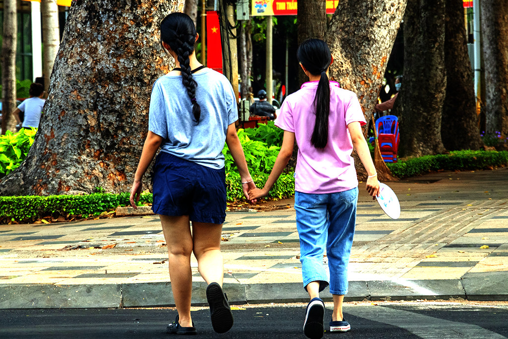Two girls walking hand in hand on 4-30-24--Vung Tau copy