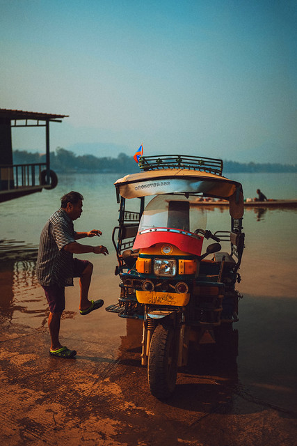 Portrait - Driver finishes washing his Tuktuk in the waters of the Mekong River (Luang Prabang)