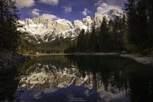 Spring at Eibsee with massif of Zugspitze and its reflections