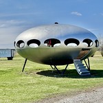 Futuro House, Veterans Memorial Drive and Livingston Avenue, Livingston, IL Manufactured sometime between 1968 and 1974 by the Futuro Corporation of Philadelphia, this Modern Futurist building is one of several Futuro houses that exist across the world, manufactured according to the design of Finnish architect Matti Suuronen.  The building, which exists as a shell with no interior, features a fiberglass shell with elliptical window openings, a steel-frame floor structure, steel support legs, and a fold-down stairway that is fixed in the open position.  Unlike many other surviving Futuro houses, this one is just a hollow shell, and has been altered with the addition of a silver paint job, covering the previous green exterior color, and has had the remainder of its windows removed.  The house is a distinctive sight along Interstate 55, and is a reminder of the optimistic and experimental architecture that evolved in the mid-20th Century.