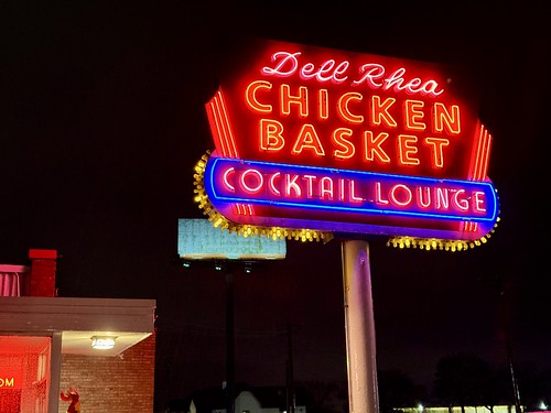 Sign, Dell Rhea’s Chicken Basket and Cocktail Lounge, Joliet Road (Old Route 66), Willowbrook, IL Built in 1946 and expanded to its present size in 1956 with the addition of a cocktail lounge on the west end of the building, this Modern building was designed by Eugene F. Stoyke to house The Chicken Basket, a restaurant that began operation in a now-demolished adjacent building in the 1930s.  The building features a buff brick exterior, a low-slope roof, large windows, a neon sign out front, and two chimneys.  Despite the section of Route 66 the restaurant sits on being bypassed by Interstate 55 in the early 1960s, the restaurant remained an open and viable business.  The building was listed on the National Register of Historic Places in 2006, and today remains in operation as a popular local diner.