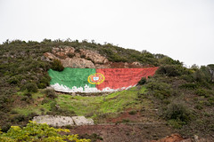 Alte, Portugal - January 24, 2020: Iconic Portugal flag painted on the mountain hillside is a landmark of the village of Alte in the Algarve region