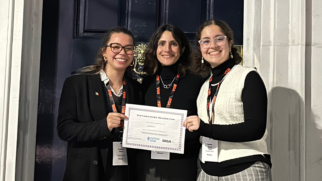 Three people smiling, holding a certificate.