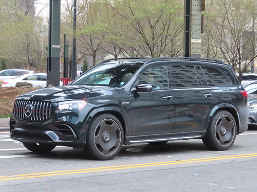 black Mercedes-Benz SUV driving down a city street