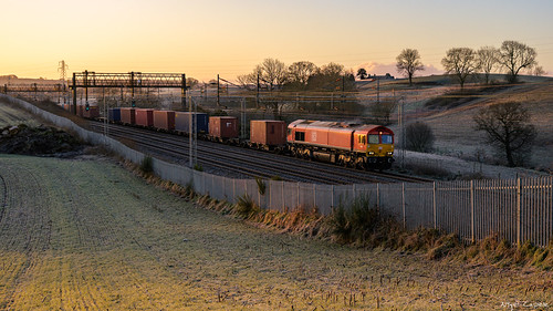 Red Shed Sunrise by Hibel Road, DB Cargo Class 66/0 No. 66019 passes Betley Road working 4M83, the 02:35 London Gateway – Trafford P