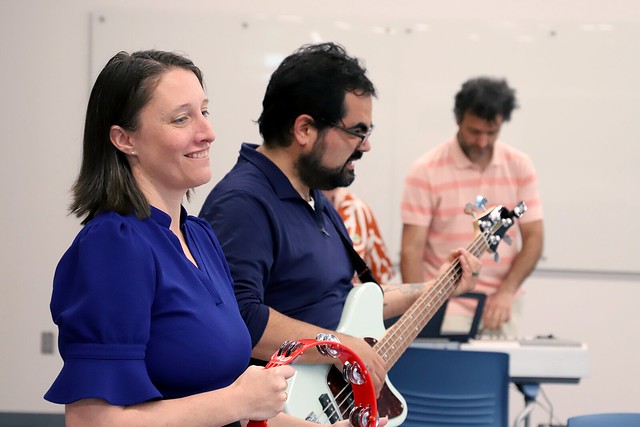 Members of the College of Education faculty band are pictured rehearsing a song.