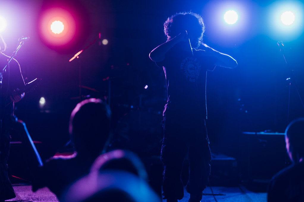 Dynamic live music performance at an outdoor festival under vibrant stage lights