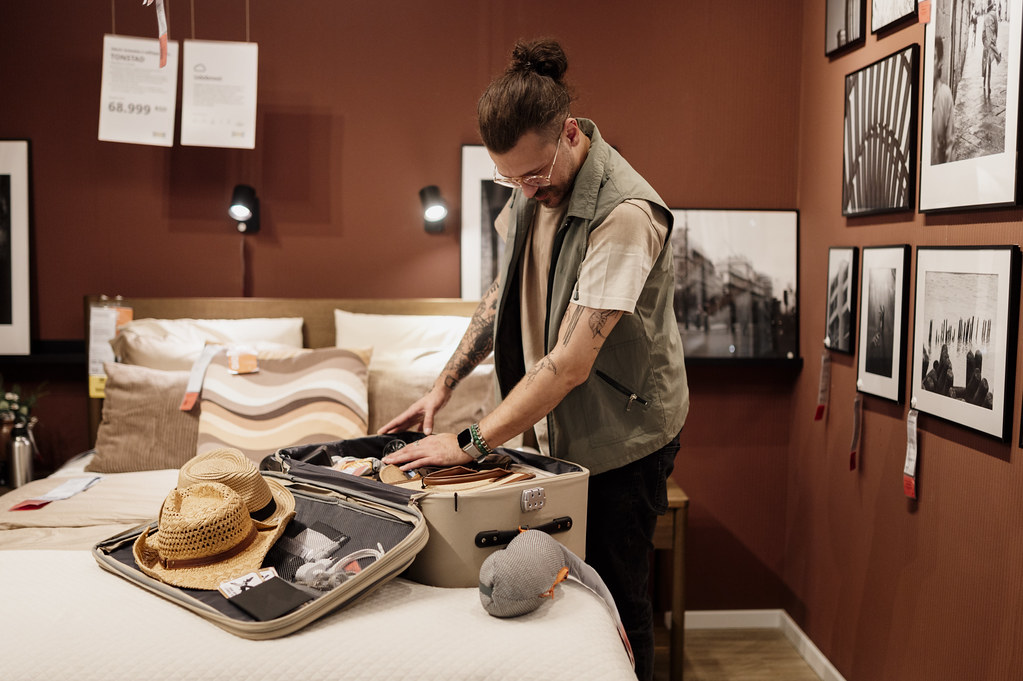 Man packing a suitcase in a hotel room
