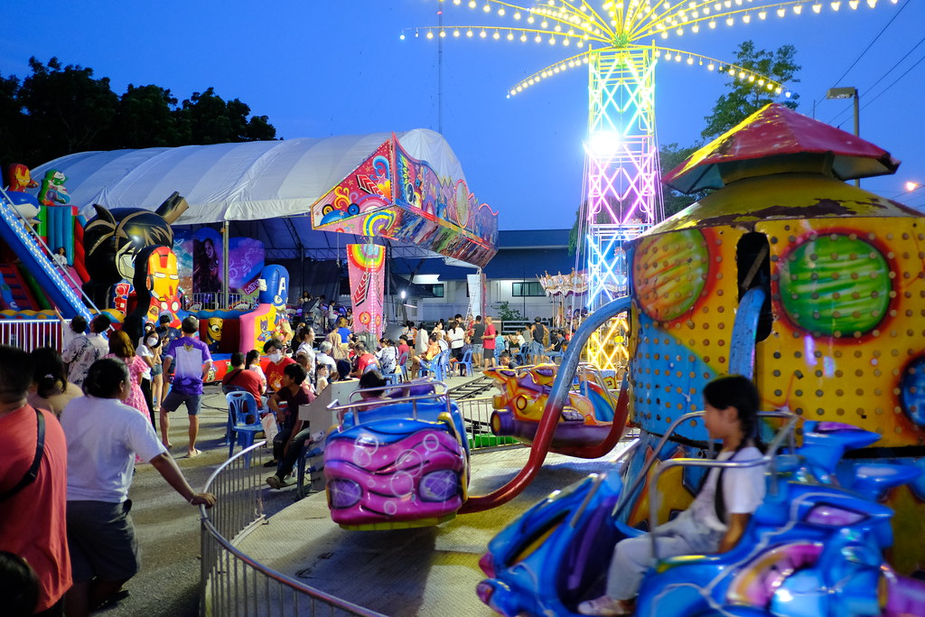 DSCF0657: a carnival ride at night with people walking around