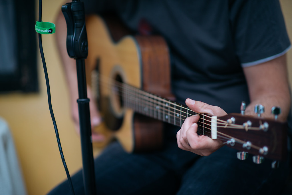 A musician skillfully plays an acoustic guitar in a cozy indoor setting