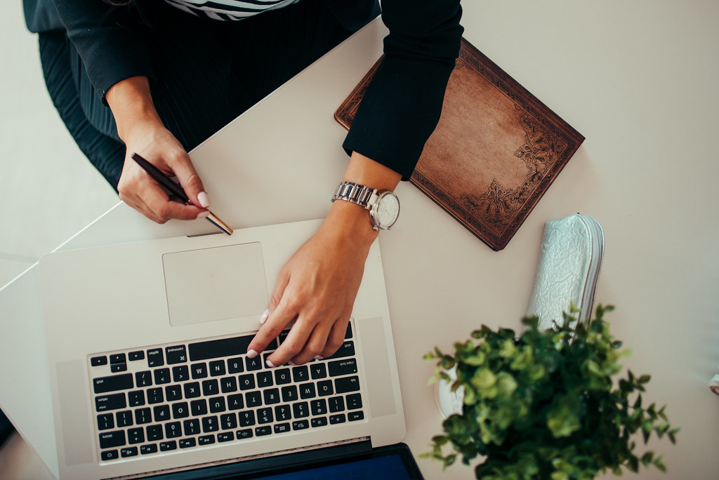 Top view of a woman working on a laptop.