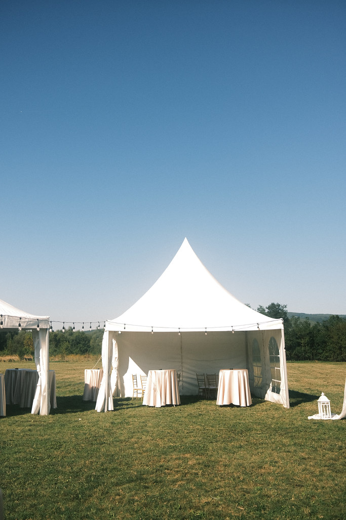 Elegant outdoor tent setup for a gathering with tables under a clear blue sky