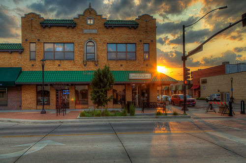 Sunset Down Walnut Street by LarryHB, A two-story brick building with green awnings stands at the edge of a quiet street as the sun sets i