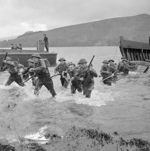 Men of the 1st Battalion, Queen's Own Royal West Kent Regiment wade ashore from landing craft during combined operations training in Scotland, 17 November 1942.
