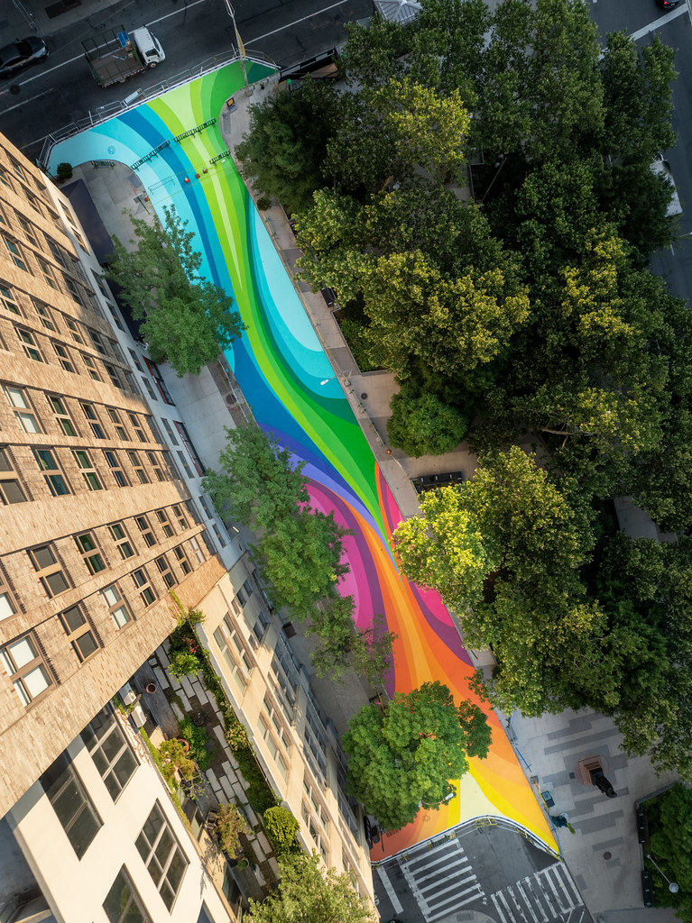 Aerial view of rainbow-colored bands across the Little Sixth Avenue plaza.