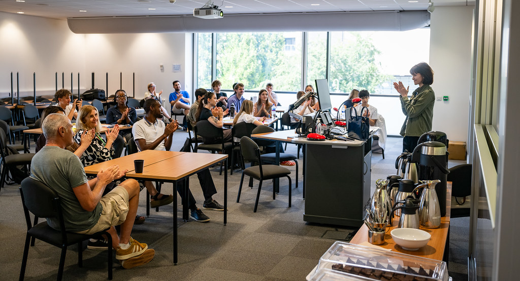 A member of staff talks to Bath Insights interns in a classroom