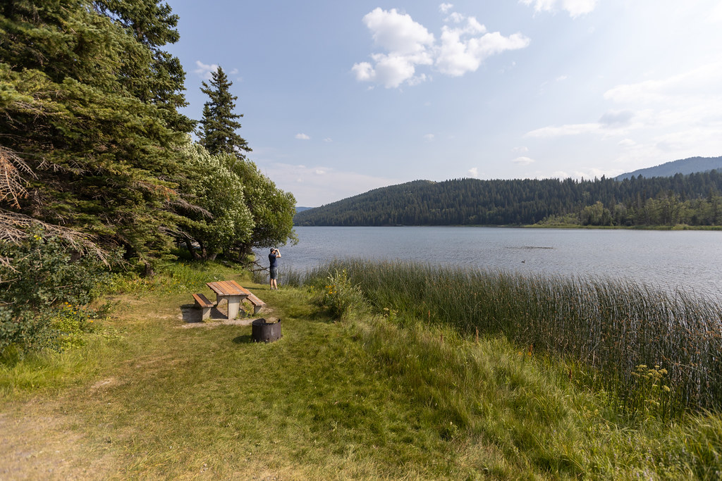 Man exploring the area with binoculars in Beauvais Lake Provincial Park, located west of Pincher Creek.